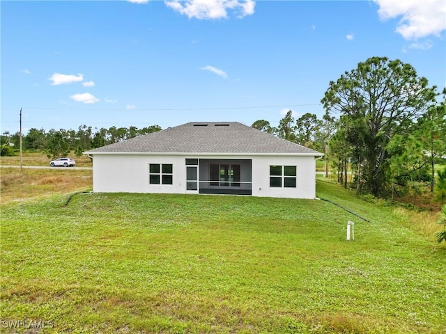 833 Newell St E, Lehigh Acres, FL 33974 - rear view of house featuring stucco siding, a lawn, and roof with shingles