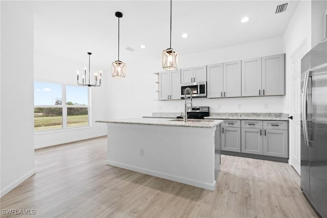 833 Newell St E, Lehigh Acres, FL 33974 - kitchen with appliances with stainless steel finishes, gray cabinetry, light wood-style floors, a chandelier, and recessed lighting
