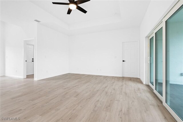 833 Newell St E, Lehigh Acres, FL 33974 - empty room with a ceiling fan, light wood-style floors, and a raised ceiling