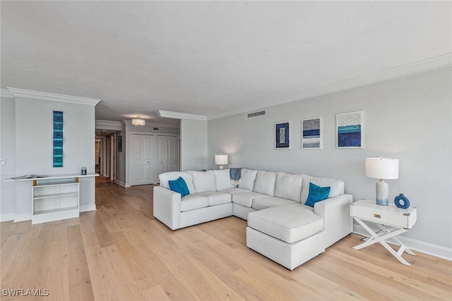 living room with light wood-type flooring and ornamental molding