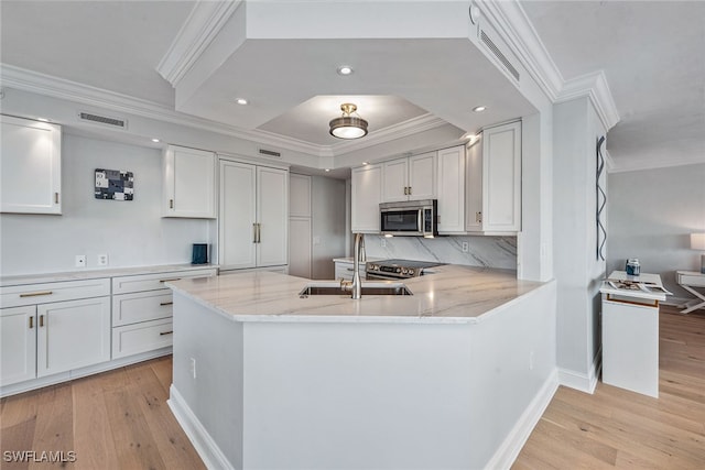 kitchen with light wood-type flooring, stainless steel appliances, and white cabinetry