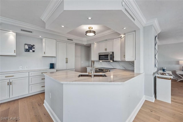 4031 Gulf Shore Blvd N Unit 95, Naples, FL 34103 - kitchen featuring stainless steel appliances, a sink, ornamental molding, light wood-style floors, and light stone counters