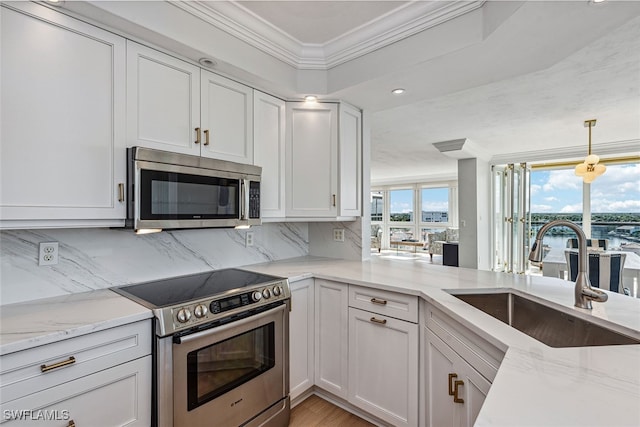 kitchen with pendant lighting, crown molding, sink, white cabinetry, and stainless steel appliances