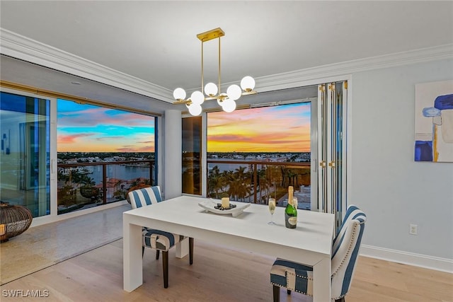 4031 Gulf Shore Blvd N Unit 95, Naples, FL 34103 - dining room featuring a chandelier, wood finished floors, crown molding, a water view, and baseboards