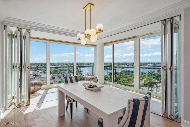 4031 Gulf Shore Blvd N Unit 95, Naples, FL 34103 - dining room with a chandelier, a water view, healthy amount of natural light, and ornamental molding