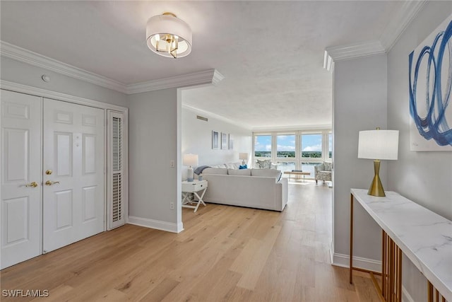 4031 Gulf Shore Blvd N Unit 95, Naples, FL 34103 - entryway with ornamental molding, light wood finished floors, baseboards, and a water view