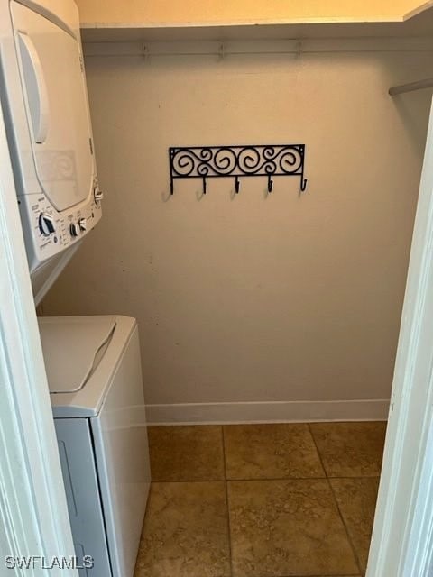 laundry room featuring stacked washing maching and dryer and tile patterned floors