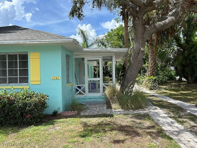 doorway to property featuring a lawn