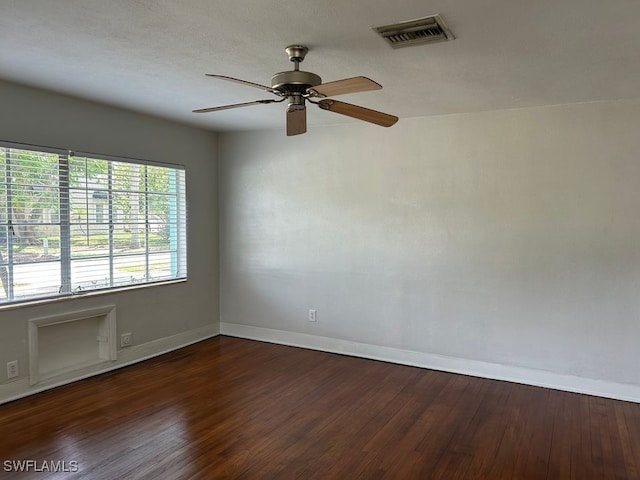 spare room with dark wood-type flooring and ceiling fan