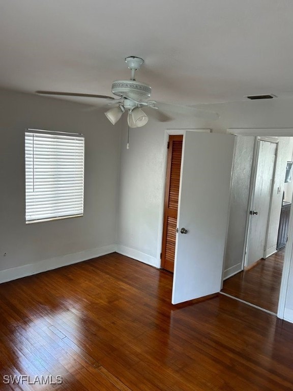 empty room with dark hardwood / wood-style floors and ceiling fan