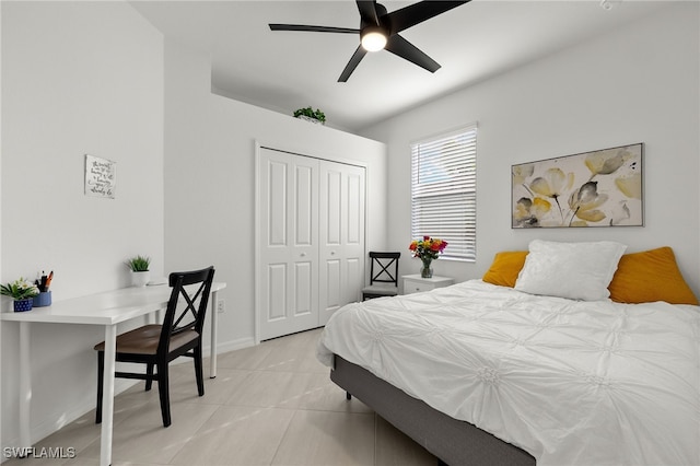 bedroom with a closet, light tile patterned floors, and ceiling fan