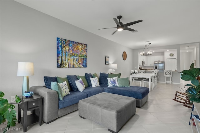 tiled living room with ceiling fan with notable chandelier