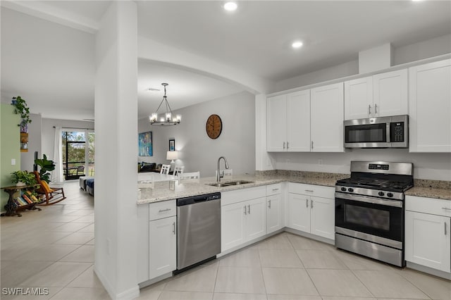 kitchen with light stone countertops, appliances with stainless steel finishes, sink, and white cabinets