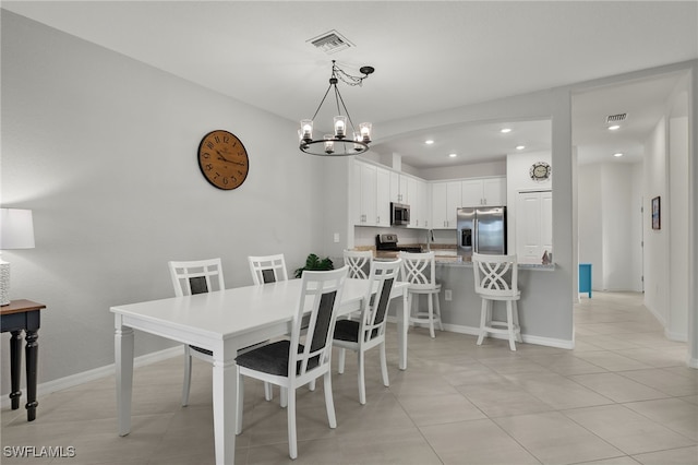 tiled dining area featuring a chandelier