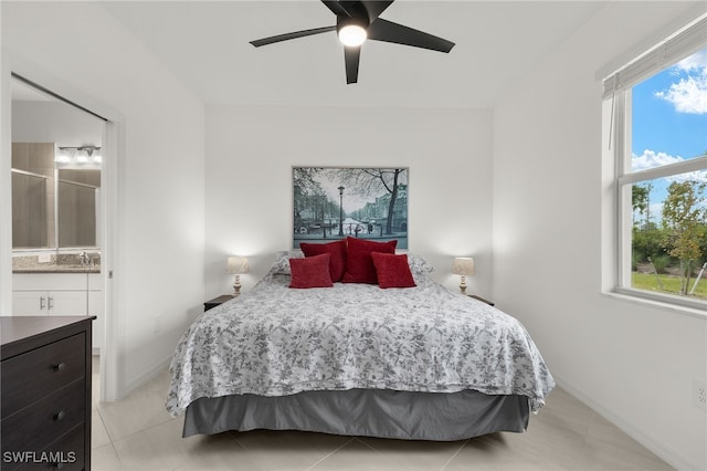 tiled bedroom featuring ensuite bathroom and ceiling fan