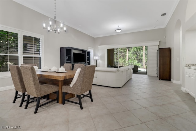 tiled dining space featuring a chandelier and ornamental molding