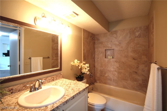 full bathroom with vanity, toilet, and tiled shower / bath