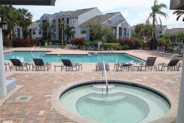 view of pool featuring a hot tub and a patio