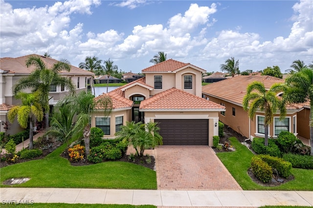 mediterranean / spanish house with a front lawn and a garage