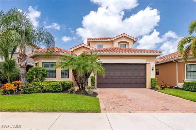 mediterranean / spanish-style house featuring a front yard and a garage