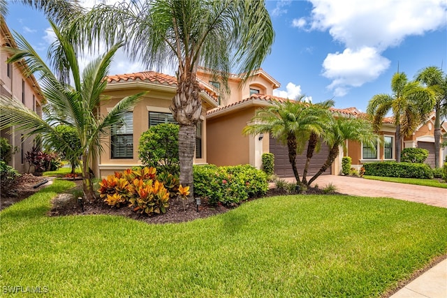 mediterranean / spanish home with a front lawn and a garage