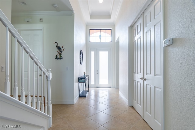 entrance foyer featuring ornamental molding and light tile patterned flooring