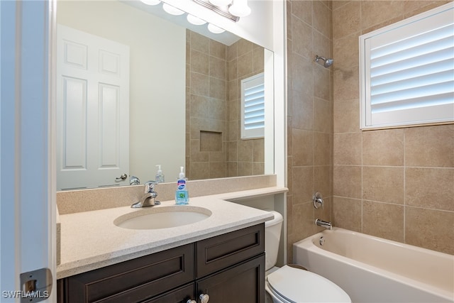 full bathroom with toilet, tiled shower / bath combo, and vanity