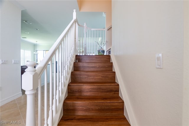 stairs with a notable chandelier and hardwood / wood-style flooring