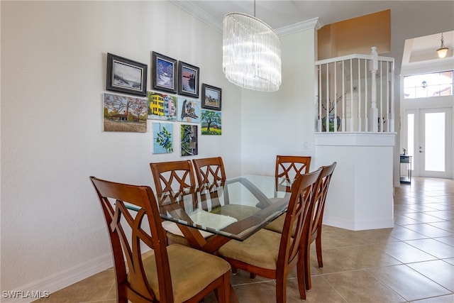 dining area with an inviting chandelier, ornamental molding, and light tile patterned floors