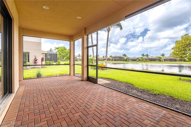 unfurnished sunroom featuring a water view