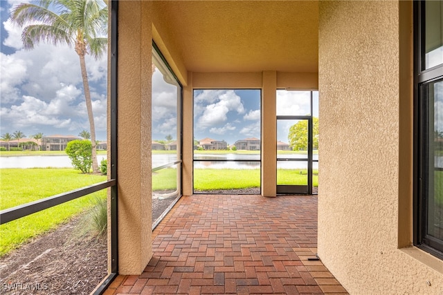 unfurnished sunroom featuring a water view