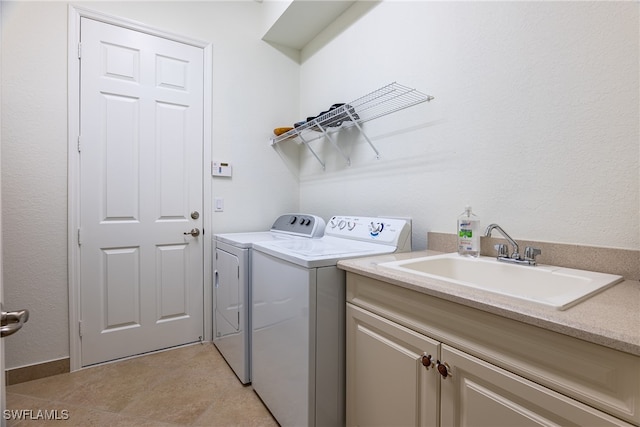 laundry area featuring cabinets, independent washer and dryer, and sink