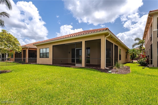 back of property featuring a yard and a sunroom