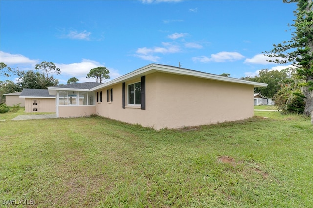 back of property featuring a yard and a sunroom