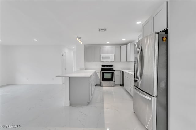 kitchen featuring kitchen peninsula, gray cabinetry, and appliances with stainless steel finishes