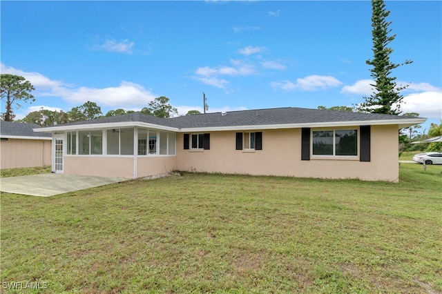 rear view of property with a sunroom, a patio area, and a yard