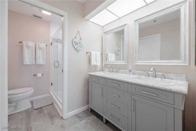 bathroom featuring a shower with door, vanity, hardwood / wood-style flooring, and toilet