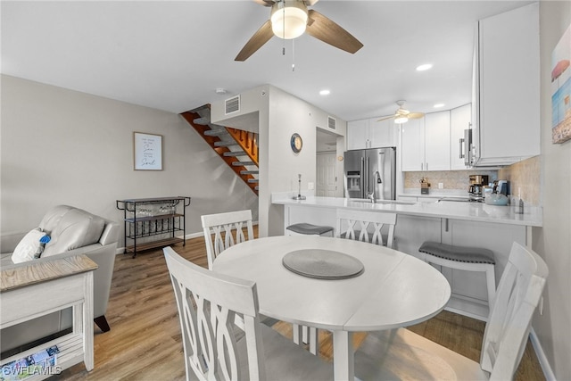 dining room featuring light hardwood / wood-style flooring, sink, and ceiling fan