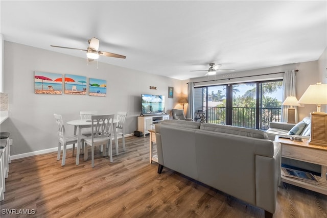 living room featuring ceiling fan and dark hardwood / wood-style flooring