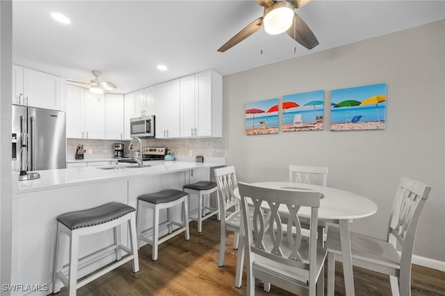 kitchen with decorative backsplash, white cabinets, stainless steel appliances, and dark hardwood / wood-style floors