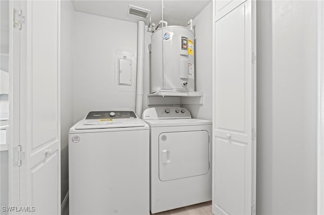 washroom with washer and clothes dryer, electric water heater, and light hardwood / wood-style floors