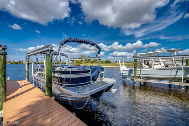 dock area with boat lift and a water view