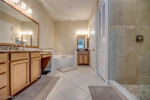 full bath featuring tile patterned floors, a garden tub, a tile shower, a closet, and vanity