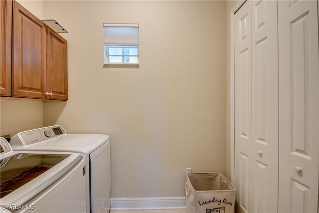 clothes washing area with baseboards, cabinet space, and washing machine and dryer