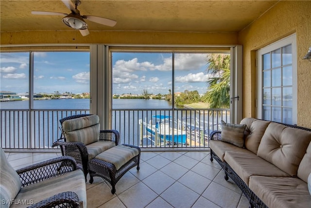 sunroom / solarium featuring a water view and ceiling fan