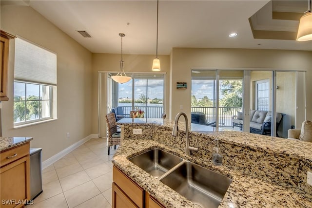 kitchen with decorative light fixtures, visible vents, plenty of natural light, and a sink