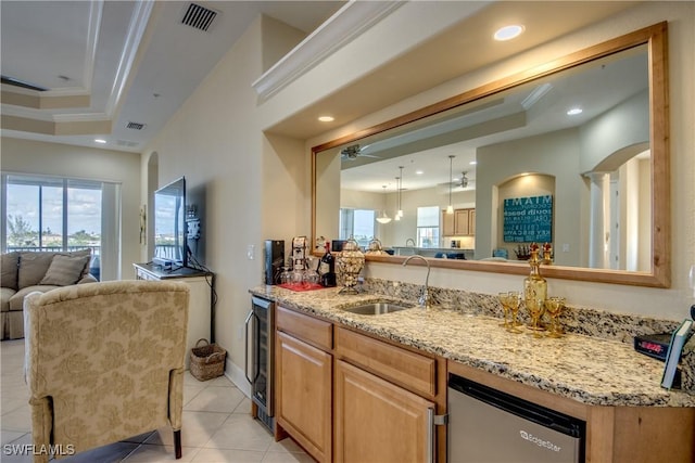 kitchen featuring light stone countertops, visible vents, a sink, crown molding, and open floor plan