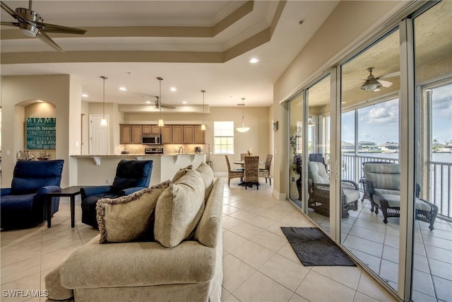 living room with light tile patterned flooring, recessed lighting, a ceiling fan, and ornamental molding