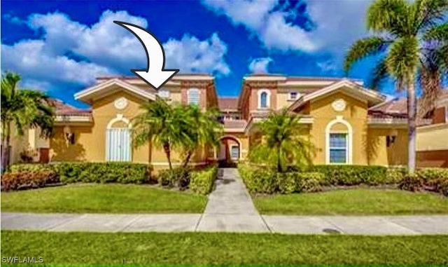 mediterranean / spanish-style home featuring stucco siding and a front yard