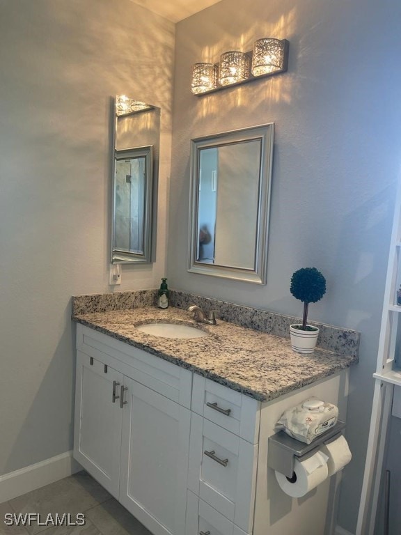 bathroom featuring tile patterned floors, baseboards, and vanity